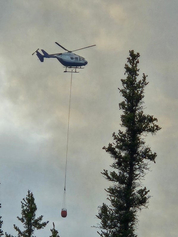 Helicopter carrying a bucket over the fire