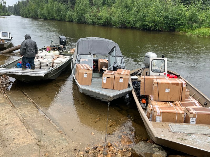Three boats loaded with boxes of supplies and hoses. 