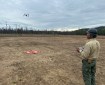 a man operates a drone on the perimeter of a wildfire