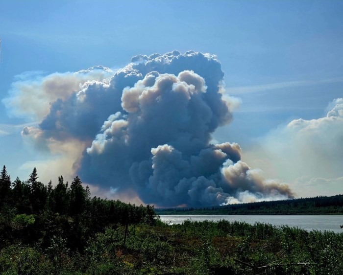 A smoke plume rises on the Lush Fire (#199). The fire is very active and pushing towards the southwest corner of the fire. The plume is rising straight up the Yukon River is on the bottom of the photograph.