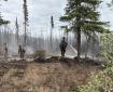 Firefighters work to cool and extinguish hotspots along the southern edge of the 7 Mile Lookout Fire.