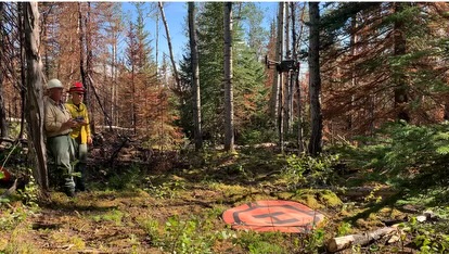 UAS operator lifting the drone to use infrared imagery on the Uncle Sam Creek Fire