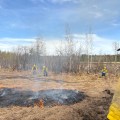 Creamers Field Echo Acres RX white Mountain Fire Crew holsing wet line and Logan Parsley, Fairbanks Area Tech supervising the fire behavior