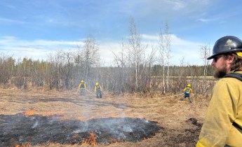 Creamers Field Echo Acres RX white Mountain Fire Crew holsing wet line and Logan Parsley, Fairbanks Area Tech supervising the fire behavior