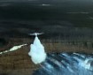 This photo shows an air tanker making a water drop on a wildland fire.