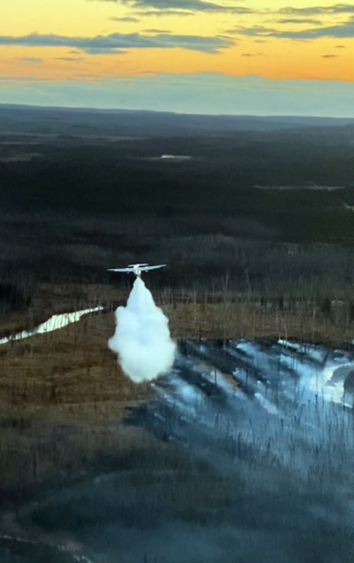This photo shows an air tanker making a water drop on a wildland fire.