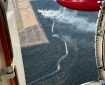 This aerial photo is looking through an aircraft's open door to a wildland fire burning below.