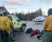 Wildland firefighters watch a landing helicopter.