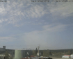 Smoke drifts up from a forest fire in in the distance. Fuel tanks are in front of the camera.