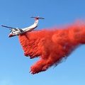 A tanker aircraft drops a load of wildland fire retardant.