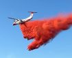 A tanker aircraft drops a load of wildland fire retardant.