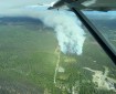 Photo from air attack plane of fire burning in black spruce alongside DFFP fuel break. Red retardant lines can be seen on north side of fire.