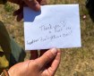 Photo of firefighter holding white envelope that reads "Thank you to all the Grandview firefighters + crew!" with a heart.