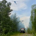 Phot of DFFP engine parked in easement, while helicopter with bucket flies overhead.
