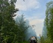 Phot of DFFP engine parked in easement, while helicopter with bucket flies overhead.