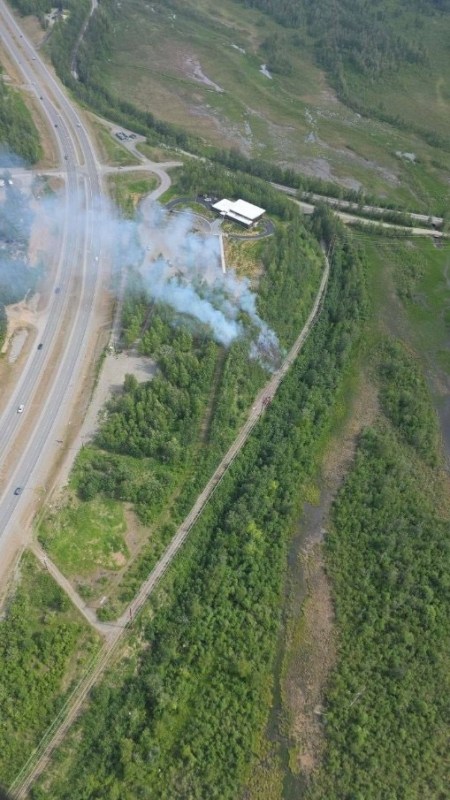 Photo of Matanuska Fire (#255) burning on right side of S Glenn Hwy in grass and hardwoods.