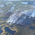 Aerial view of the Kanuti Fire, burning in tundra and trees among lakes and small water bodies in the tundra.