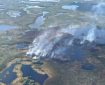 Aerial view of the Kanuti Fire, burning in tundra and trees among lakes and small water bodies in the tundra.
