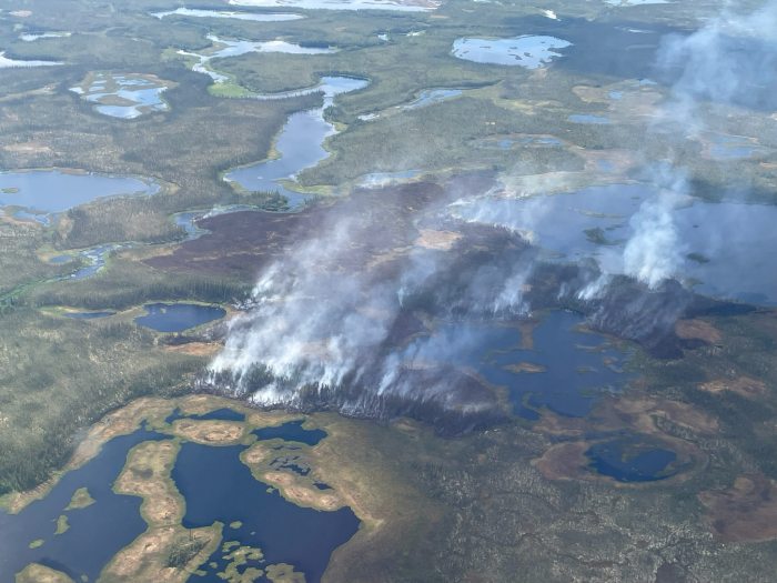 Aerial view of the Kanuti Fire, burning in tundra and trees among lakes and small water bodies in the tundra.