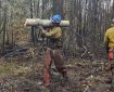 Firefighter Vincent Wade carries a log