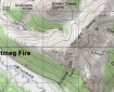 Red dot showing location of Nutmeg Fire on a topographic map with lines and green shaded areas.