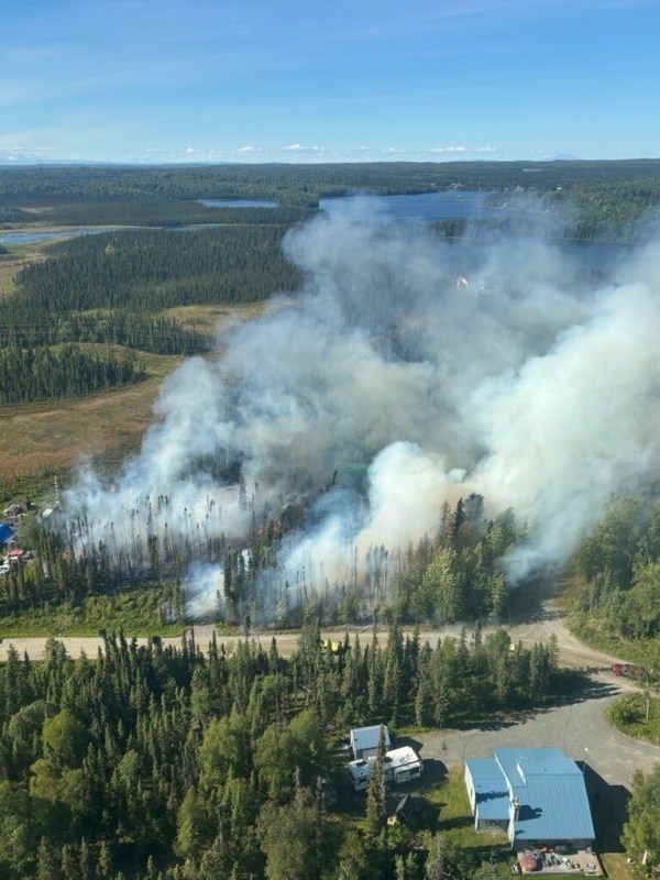 Aerial image of the fire with smoke rising from the center and to the right of the photo. Several structures are visible on the lower portion of the photo.