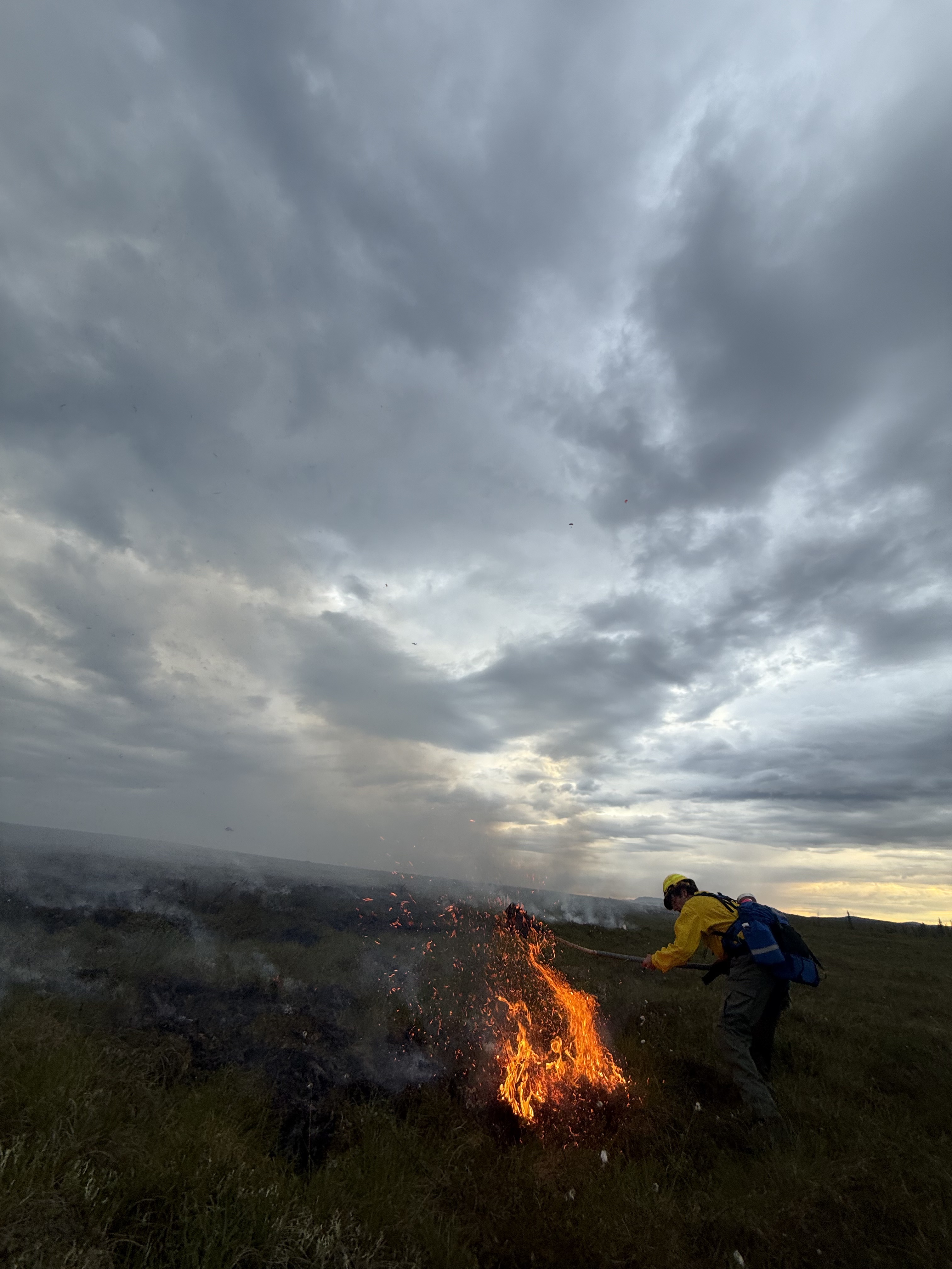 A firefighter works to extinguish flame while working on the Owhat fire.