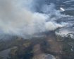 Smoke billows up from a fire burning between lakes.